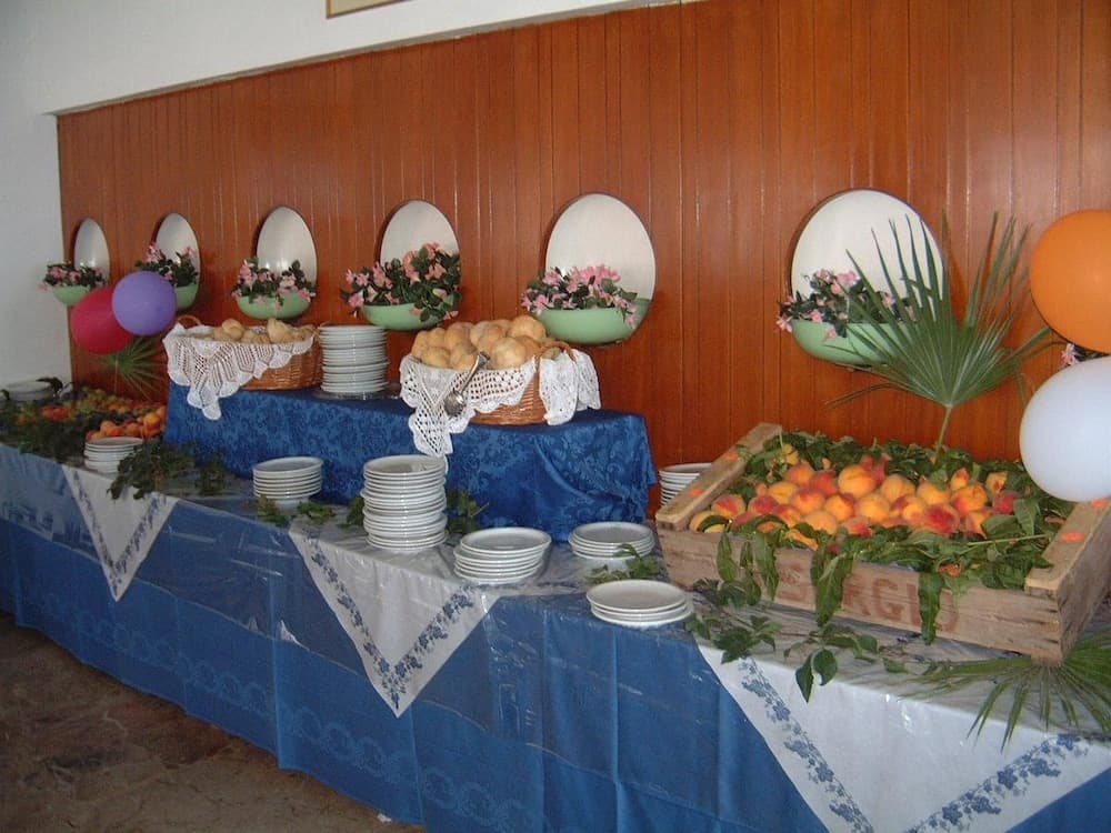 A festive indoor buffet table adorned with fresh fruits, floral arrangements, and decorative balloons creates a cheerful dining atmosphere ideal for family gatherings or celebrations.