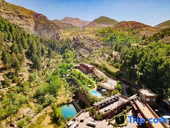 A serene mountain resort nestled in lush greenery with vibrant blue pools and terraced landscapes offers a tranquil escape for travelers seeking relaxation amidst nature.