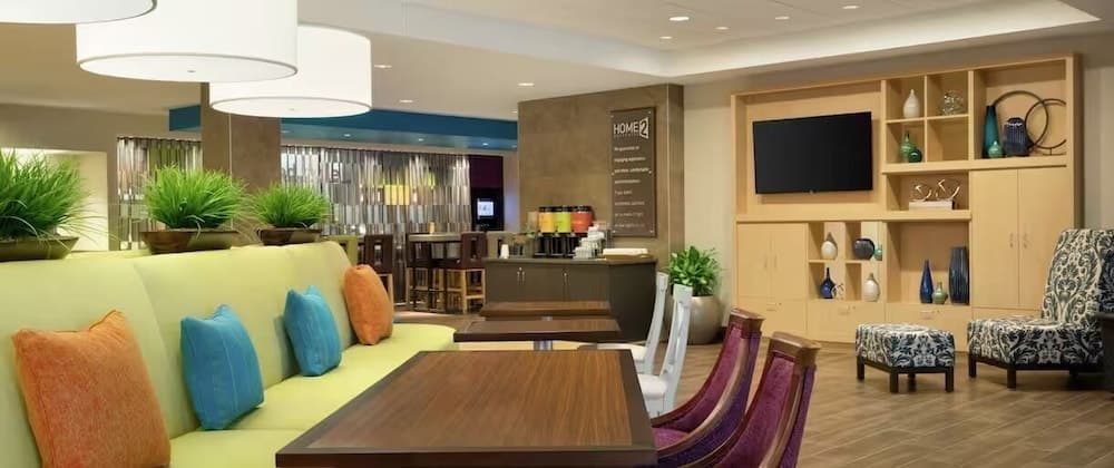 A cozy hotel lobby features vibrant seating areas, modern decor, and a welcoming atmosphere, ideal for travelers seeking relaxation or business meetings.