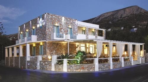 A cozy evening scene at a charming stone-built restaurant with warm lighting and outdoor seating, nestled against a mountain backdrop, ideal for travelers seeking a serene dining experience in a picturesque setting.