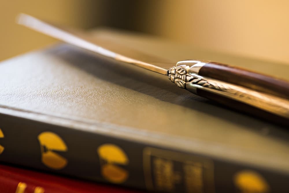 A close-up of an ornate sword resting on leather-bound books evokes a scholarly ambiance, ideal for travelers seeking historical or literary exploration.