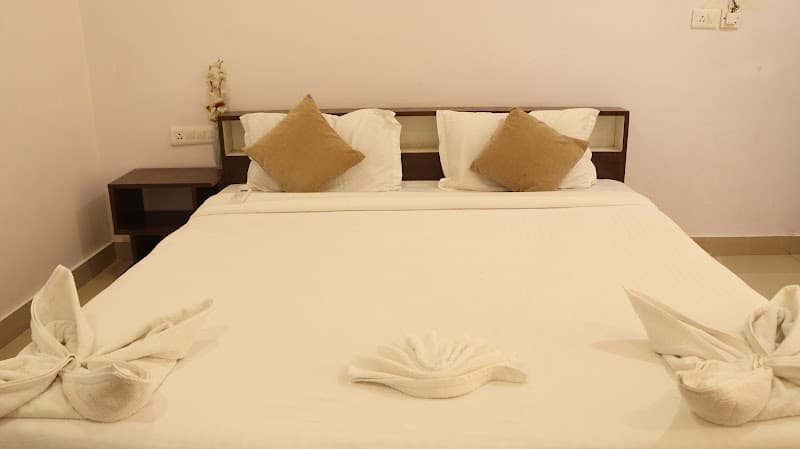 A cozy hotel room at The Aroma Resort in Havelock, Andaman and Nicobar Islands, features neatly arranged beds with decorative towel art, inviting travelers seeking relaxation and comfort during their beachside getaway.