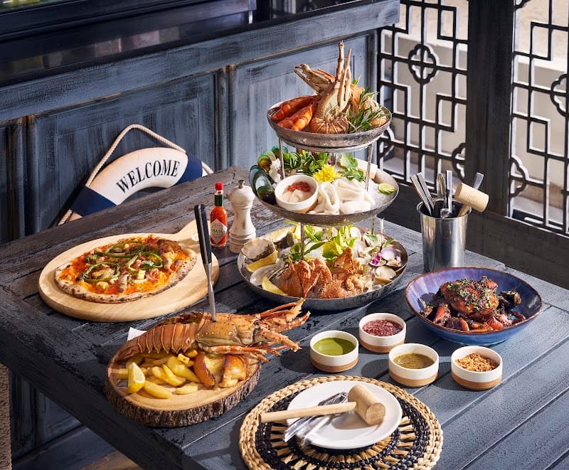A lavish seafood feast spread on a rustic wooden table at the Anantara Lawana Koh Samui Resort invites travelers to indulge in gourmet dining amidst elegant decor, perfect for luxury vacation inspiration.
