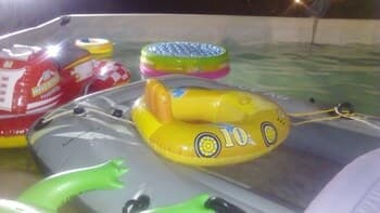 A vibrant poolside scene featuring colorful inflatable toys like a yellow duck and a red car creates a playful and fun atmosphere, ideal for family-friendly vacation activities.