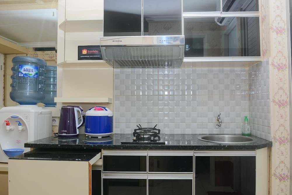 A cozy kitchen with tiled backsplash, stainless steel sink, and modern appliances creates a functional and inviting space ideal for travelers seeking self-catering accommodations.