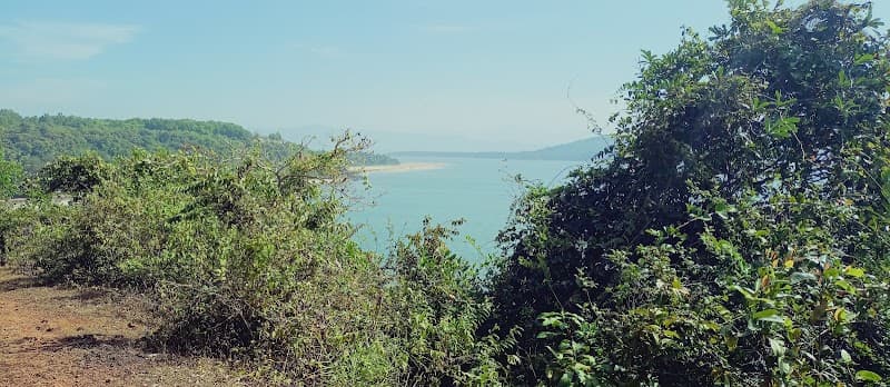 A serene coastal trail framed by lush greenery offers breathtaking views of the tranquil sea, ideal for nature lovers seeking a peaceful escape in Karnataka, India.