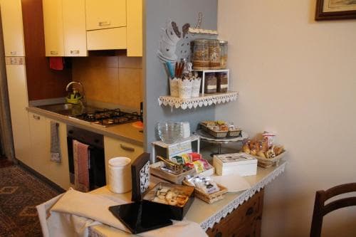 A cozy kitchen corner with a rustic table adorned with baked goods and decorative items, evoking a warm, homely atmosphere ideal for travelers seeking a quaint, inviting accommodation experience.