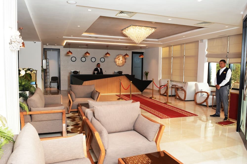 A luxurious hotel lobby features plush seating, elegant chandeliers, and attentive staff, creating a welcoming atmosphere ideal for travelers seeking comfort and hospitality.
