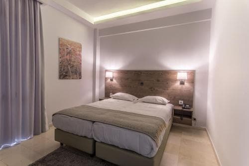 A cozy hotel bedroom features a neatly made bed with a wooden headboard, soft lighting, and modern decor, ideal for travelers seeking comfort and relaxation.