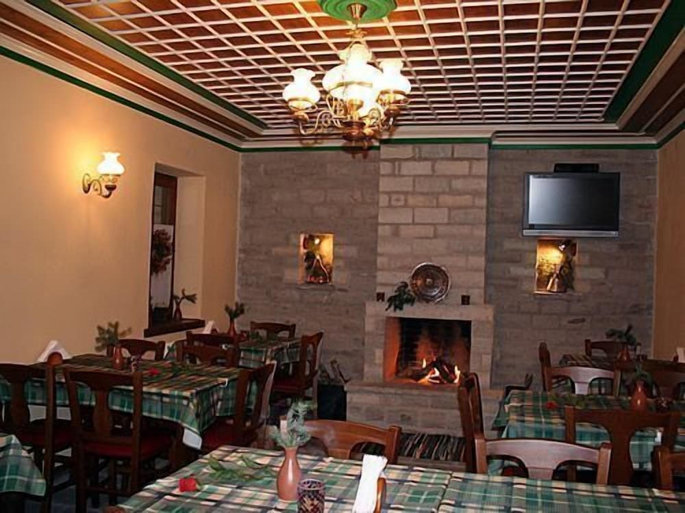 A cozy restaurant with a warm fireplace, checkered tablecloths, and rustic decor offers an inviting atmosphere for travelers seeking a traditional dining experience.