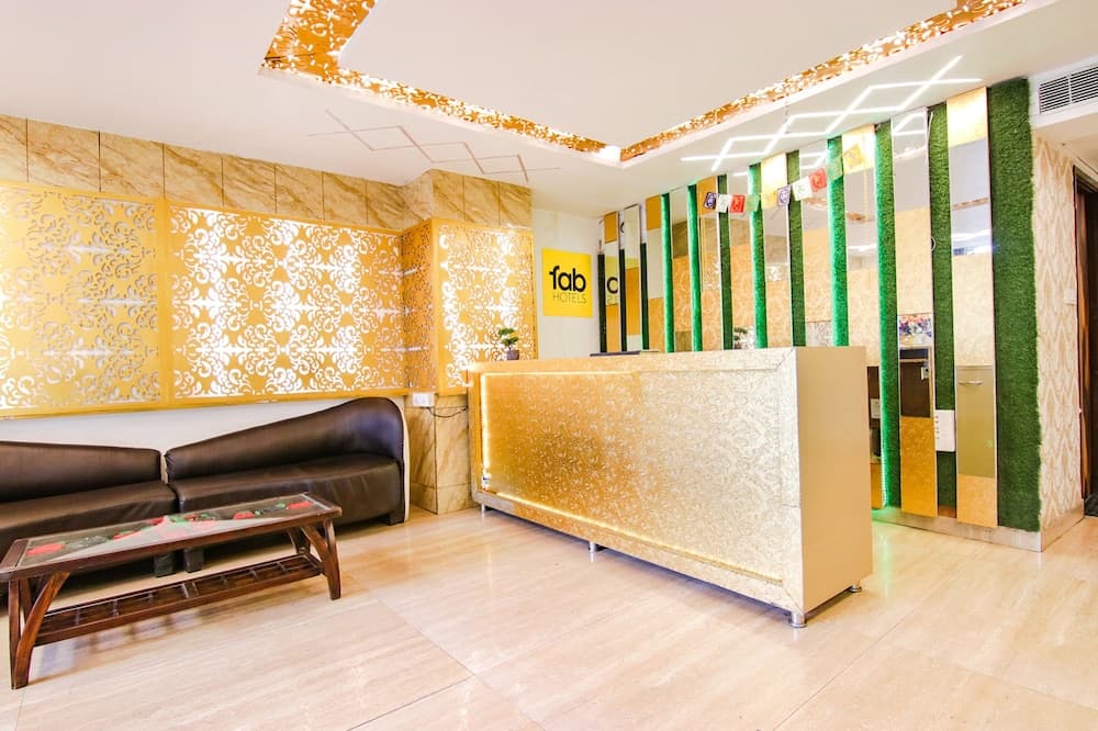 A vibrant hotel lobby features golden accents, patterned walls, and modern furnishings, creating a welcoming atmosphere ideal for travelers seeking comfort and style.