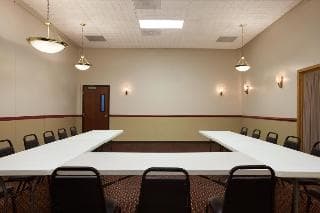 A well-lit conference room with long tables and chairs set up for meetings or workshops, ideal for business travelers seeking professional venues.
