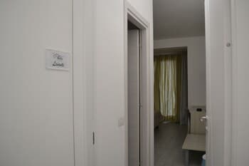 A cozy hotel room hallway leads to a warmly lit interior with yellow curtains, inviting travelers seeking comfort and privacy.