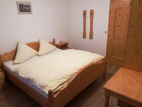 A cozy bedroom with wooden furniture and simple decor offers a serene retreat, ideal for travelers seeking a peaceful accommodation experience.