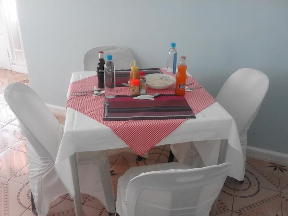 A cozy dining area with a white tablecloth, red checkered runner, and assorted condiments creates an inviting atmosphere for travelers seeking a comfortable meal spot.