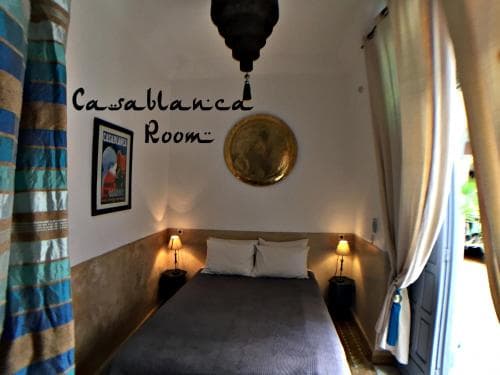 A cozy Casablanca-themed bedroom with soft lighting, patterned curtains, and vintage decor invites travelers seeking a romantic and intimate stay.