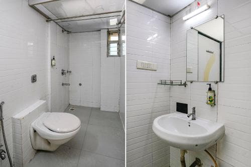 A compact, clean bathroom with white tiled walls, a wall-mounted toilet, sink, mirror, and small window, ideal for travelers seeking efficient and functional accommodation spaces.