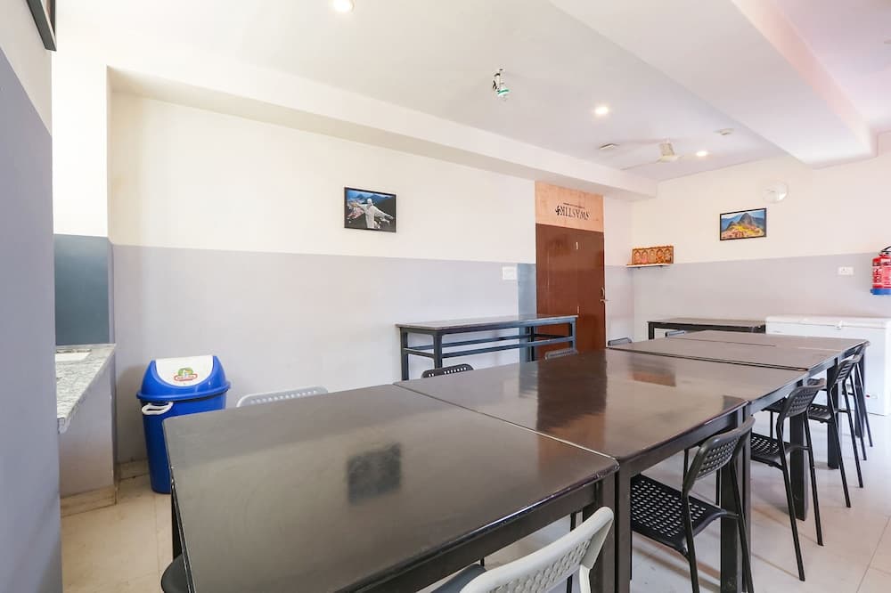 A cozy indoor dining area features sleek tables, chairs, and minimalist decor, ideal for travelers seeking a quiet spot to enjoy meals or work in a relaxed atmosphere.