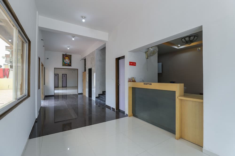 A serene hotel lobby features a polished floor, a wooden reception desk, and a calm atmosphere, ideal for travelers seeking a peaceful check-in experience.