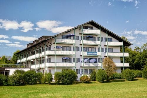 A serene multi-story hotel with balconies and lush greenery under a bright blue sky offers an inviting retreat for travelers seeking relaxation in a picturesque setting.