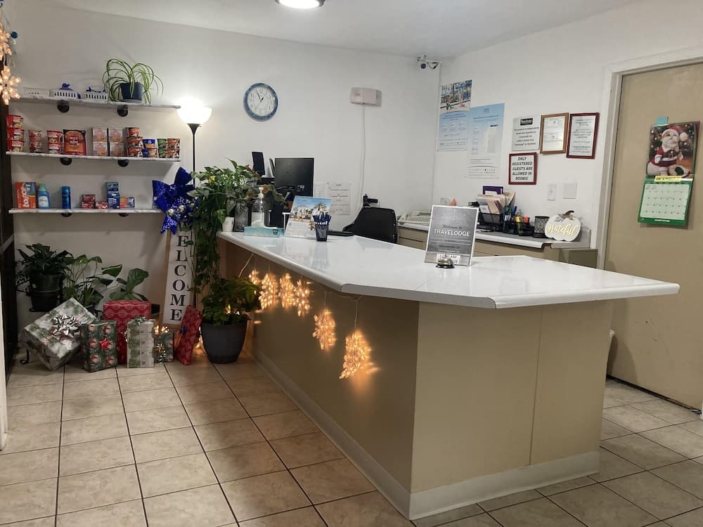 A cozy hotel reception adorned with festive decorations, including twinkling lights and wrapped gifts, creates a welcoming atmosphere ideal for travelers seeking a warm and inviting stay during the holiday season.