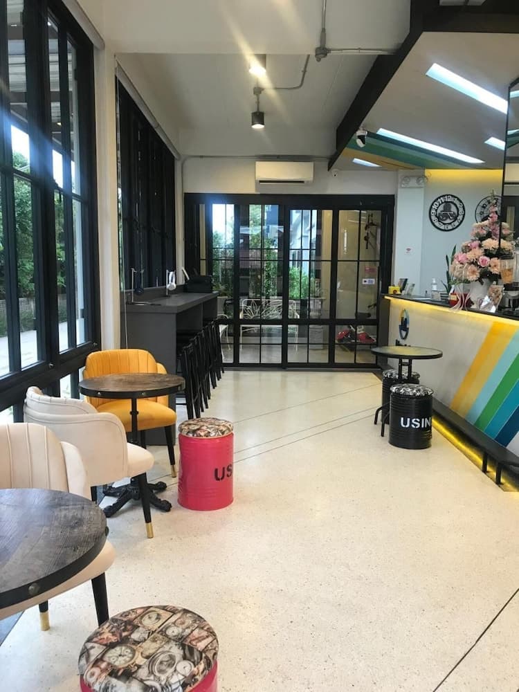 A cozy café with vibrant seating options, large windows, and a colorful counter creates an inviting atmosphere perfect for travelers seeking a relaxing spot to unwind and enjoy refreshments.