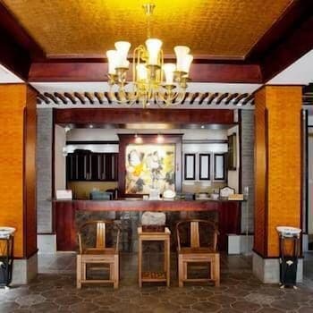 A warmly lit traditional reception area with wooden furniture, ornate chandeliers, and cultural artwork creates an inviting atmosphere ideal for travelers seeking a luxurious and culturally immersive experience.