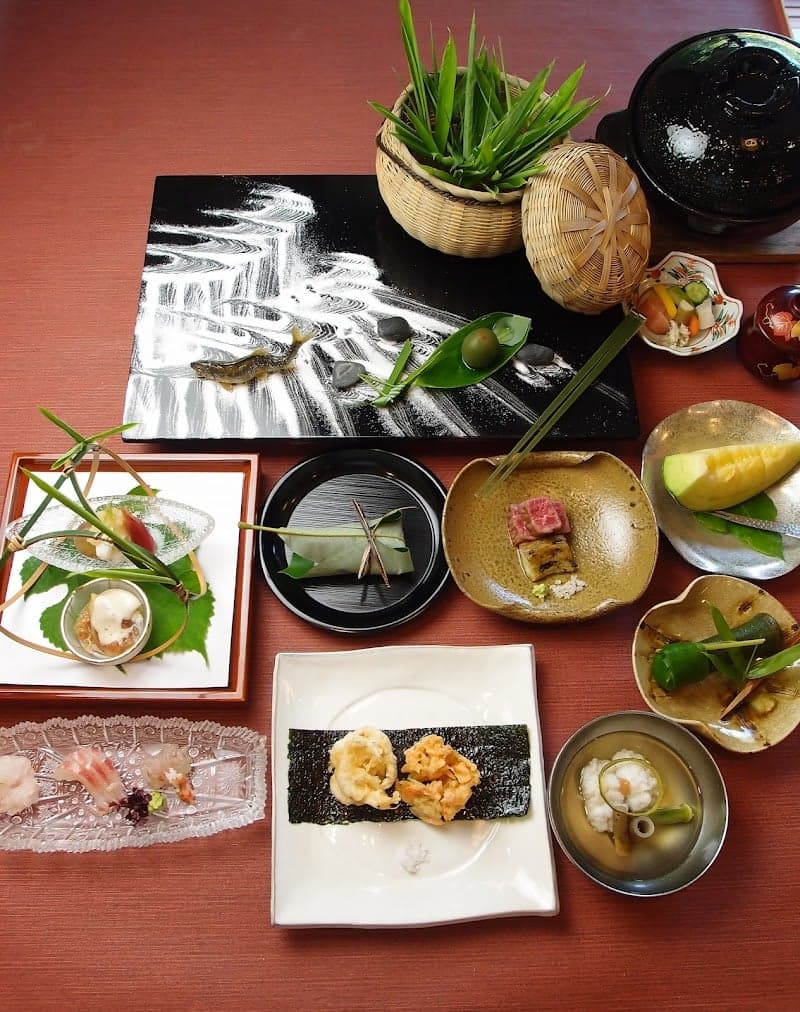 A serene dining scene at a traditional Japanese ryokan features an exquisite kaiseki meal artfully arranged on a red table, complete with delicate sushi, tempura, and garnished dishes, evoking a sense of culinary elegance ideal for cultural immersion travelers seeking authentic gastronomic experiences.