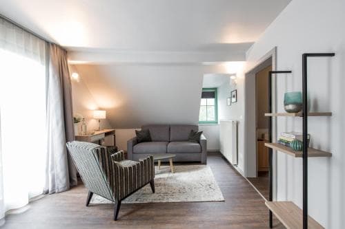 A cozy, modern living room with wooden floors, soft lighting, and stylish furniture creates an inviting atmosphere, perfect for travelers seeking a comfortable and chic accommodation space.