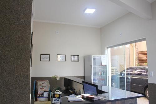 A cozy office space with framed pictures, a glass partition revealing parked cars outside, and a casual work setup, ideal for travelers seeking a quiet workspace in an urban setting.