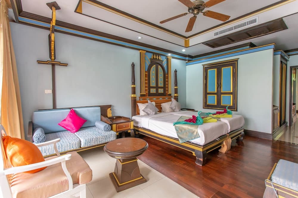 A cozy hotel room features vibrant decor with wooden furnishings, colorful textiles, and a serene ambiance, ideal for travelers seeking comfort and cultural charm.
