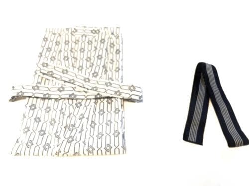 A neatly folded patterned scarf paired with a striped tie against a clean white background, ideal for travelers seeking stylish accessories for versatile outfits.