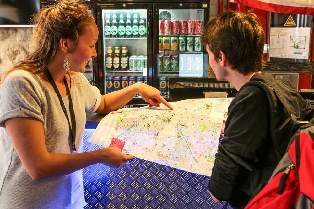 A cheerful traveler consults a city map at a vibrant kiosk counter, surrounded by refrigerated beverages, ideal for urban exploration planning.