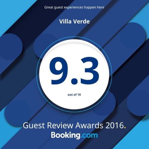 A vibrant graphic featuring bold blue geometric shapes highlights Villa Verde's impressive 9.3 out of 10 guest review score, celebrating its 2016 Booking.com Guest Review Award, ideal for travelers seeking top-rated accommodations.