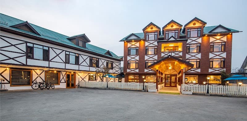 A charming resort with traditional architecture illuminated by warm lights creates a cozy evening atmosphere, featuring bicycles and a welcoming entrance, ideal for travelers seeking relaxation in a picturesque setting.