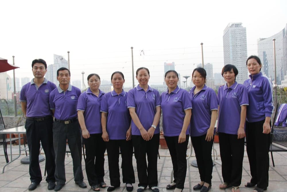 A group in matching purple shirts stands together on an urban rooftop terrace, creating a professional and cohesive atmosphere ideal for team-building retreats or corporate events.