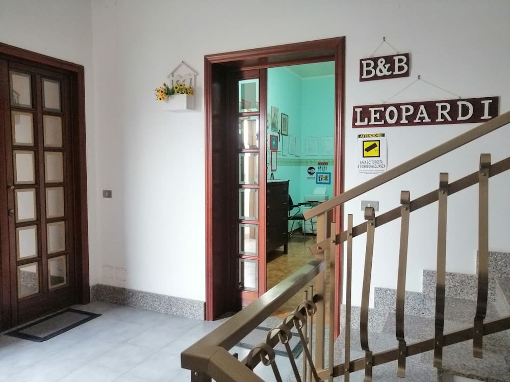 A cozy B&B entrance featuring a staircase, wooden doors, and a welcoming signboard creates an inviting atmosphere for travelers seeking comfortable accommodations.