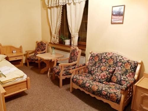 A cozy hotel room features floral-patterned furniture, wooden accents, and soft lighting, creating a warm and inviting atmosphere ideal for travelers seeking comfort and relaxation.