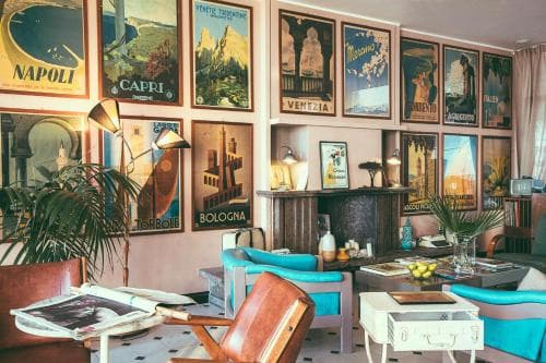 A cozy living room adorned with vintage travel posters evokes a nostalgic mood, featuring stylish mid-century furniture and plants, perfect for travelers seeking inspiration or a unique interior design idea.