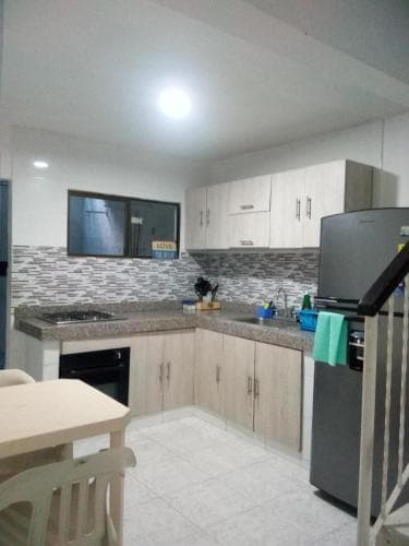 A cozy, modern kitchen with light wood cabinets, tiled backsplash, and stainless steel appliances creates a welcoming atmosphere ideal for travelers seeking a homey rental experience.