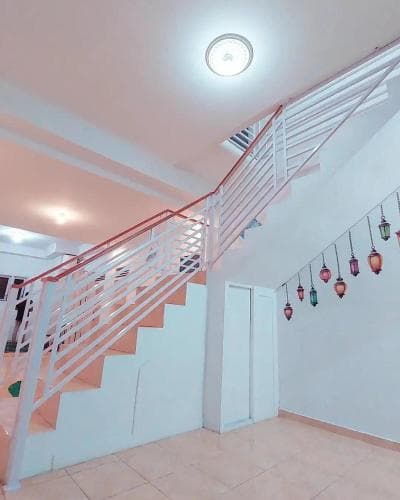 A cozy indoor staircase adorned with colorful hanging lanterns creates a warm and inviting atmosphere, perfect for travelers seeking a charming accommodation experience.