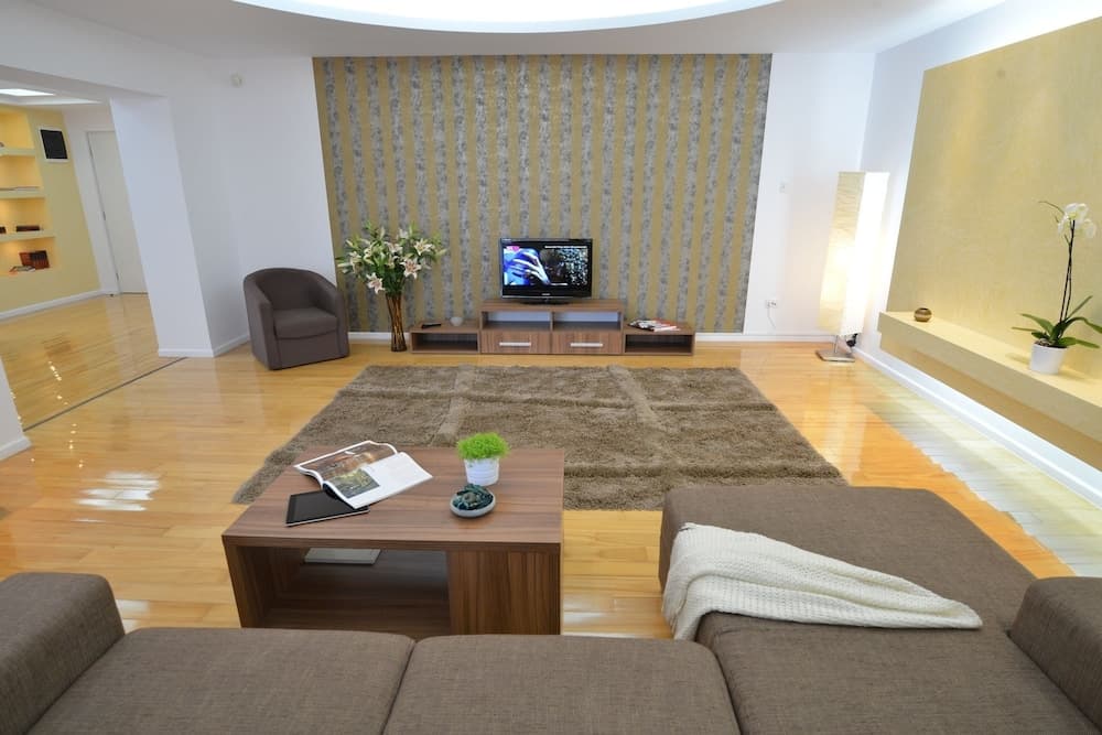 A cozy modern living room with hardwood floors, a plush rug, contemporary furniture, and decorative elements creates an inviting atmosphere ideal for interior design inspiration and home staging purposes.