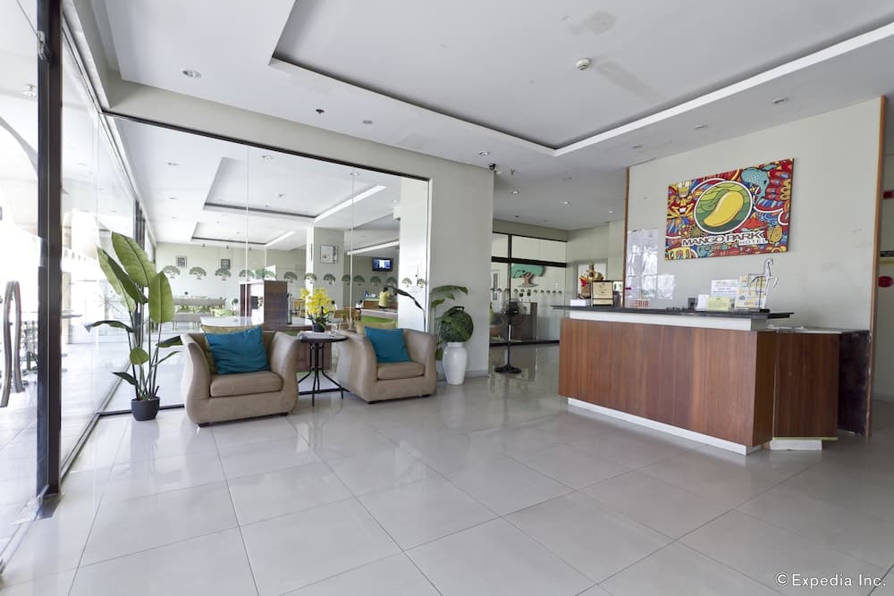 A bright and welcoming hotel lobby features modern furnishings, vibrant artwork, and large windows, ideal for travelers seeking comfort and convenience during their stay.