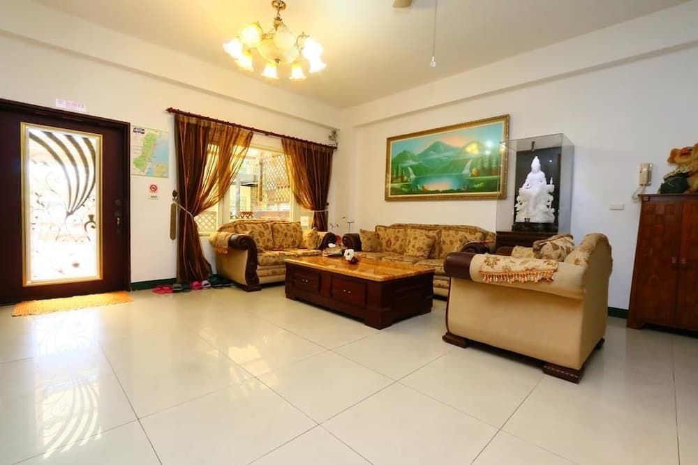 A cozy living room with beige sofas, a wooden coffee table, and warm lighting creates an inviting atmosphere, perfect for travelers seeking a comfortable stay in a homely environment.