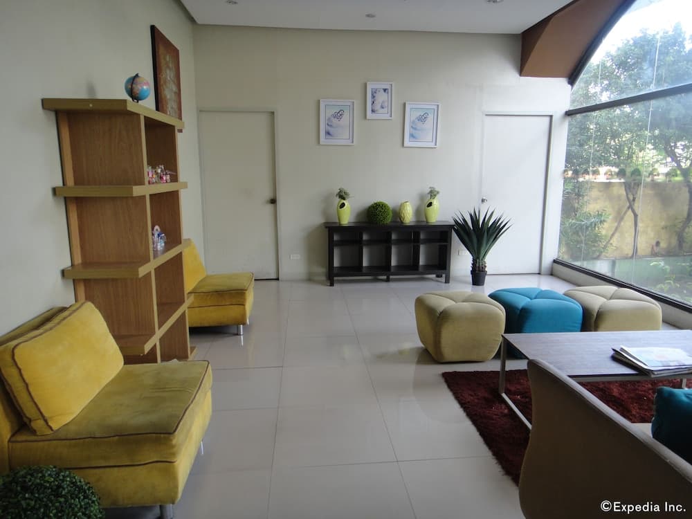 A bright, modern living room with yellow sofas, wooden shelves, and large windows overlooking greenery, ideal for travelers seeking a cozy and stylish accommodation space.
