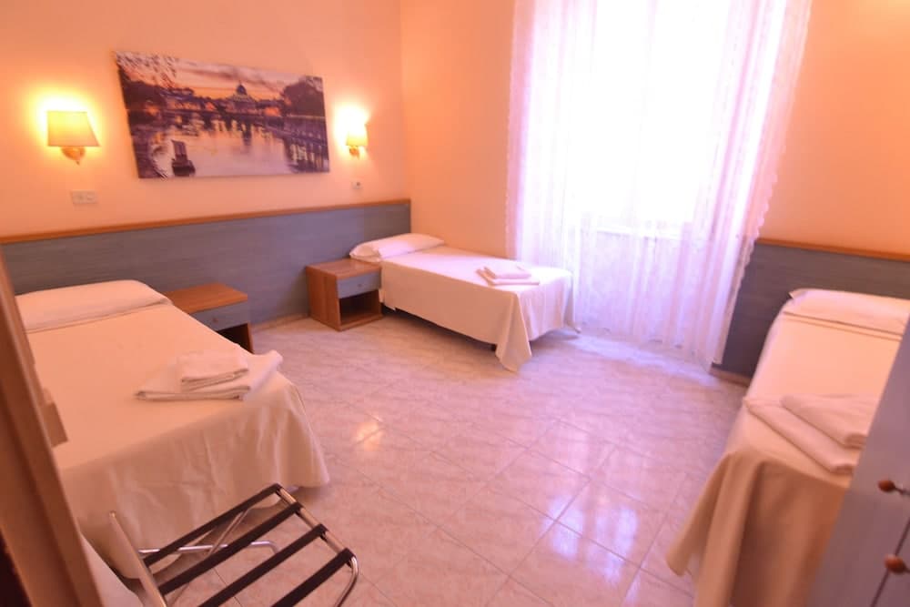 A cozy hotel room with neatly arranged twin beds, soft lighting, a serene wall painting, and sheer curtains filtering natural light, ideal for travelers seeking comfort and tranquility.