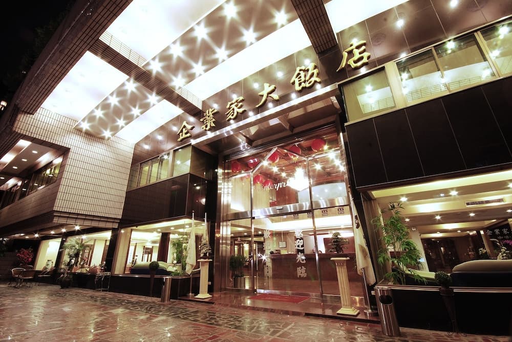 A warmly lit hotel entrance adorned with star-shaped lights and Chinese characters exudes a welcoming ambiance, perfect for travelers seeking a cozy stay in an urban setting.
