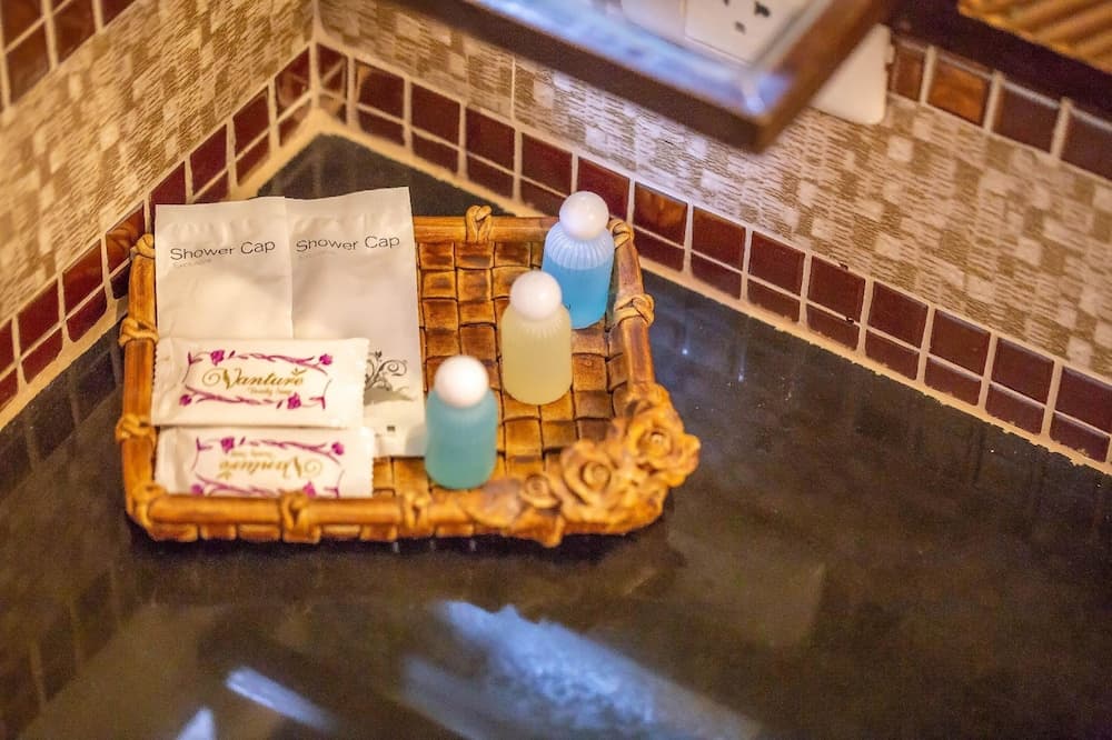 A cozy bathroom countertop features a decorative basket holding toiletries like shower caps and bottles, set against a tiled wall, ideal for travelers seeking comfort and convenience in their accommodations.