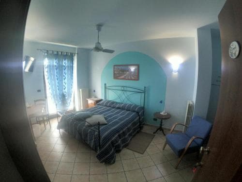 A cozy hotel room with tiled floors, a blue-themed decor, and a comfortable bed invites travelers seeking a serene and budget-friendly accommodation experience.