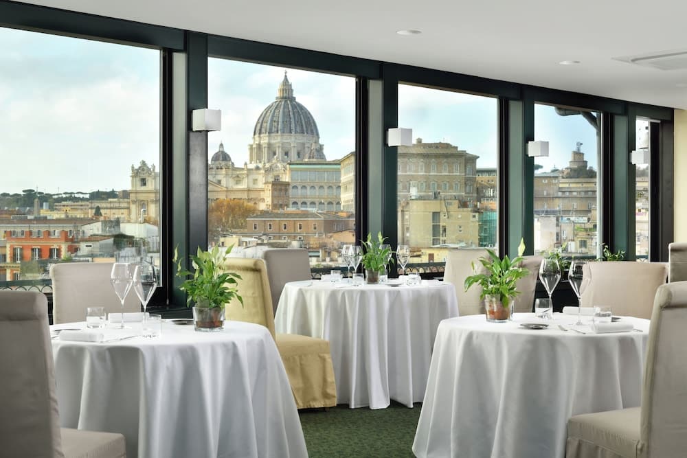 An elegant restaurant with panoramic views of a historic cityscape featuring a grand dome, ideal for travelers seeking a luxurious dining experience with cultural ambiance.